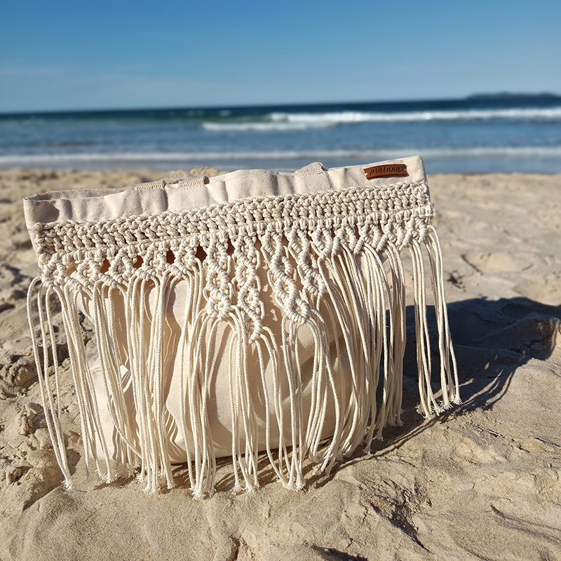 Eco Bag Essencial em algodão cru e macramê sobre a areia da praia