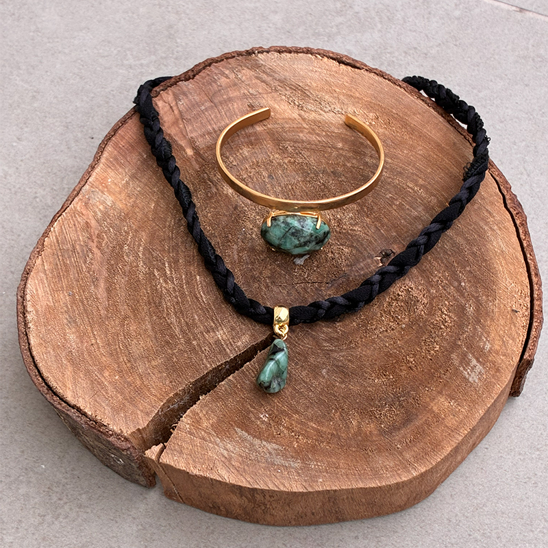 Conjunto Enlace Esmeralda: colar trançado e bracelete dourado com pedra verde